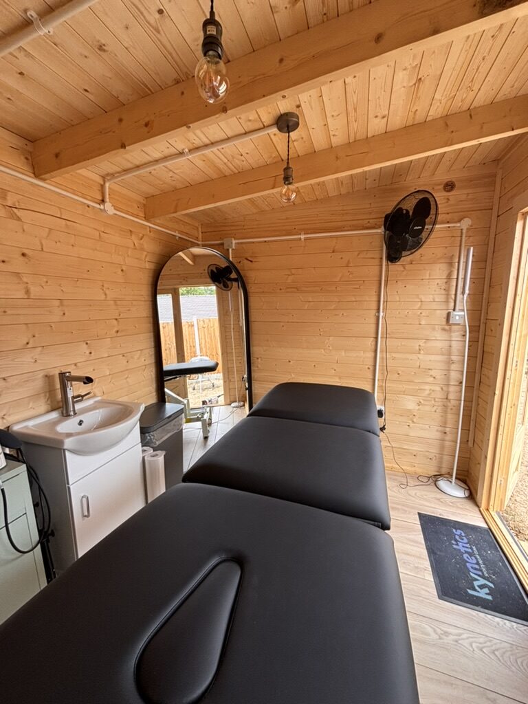Sports therapy treatment room inside the garden studio, with couch and sink