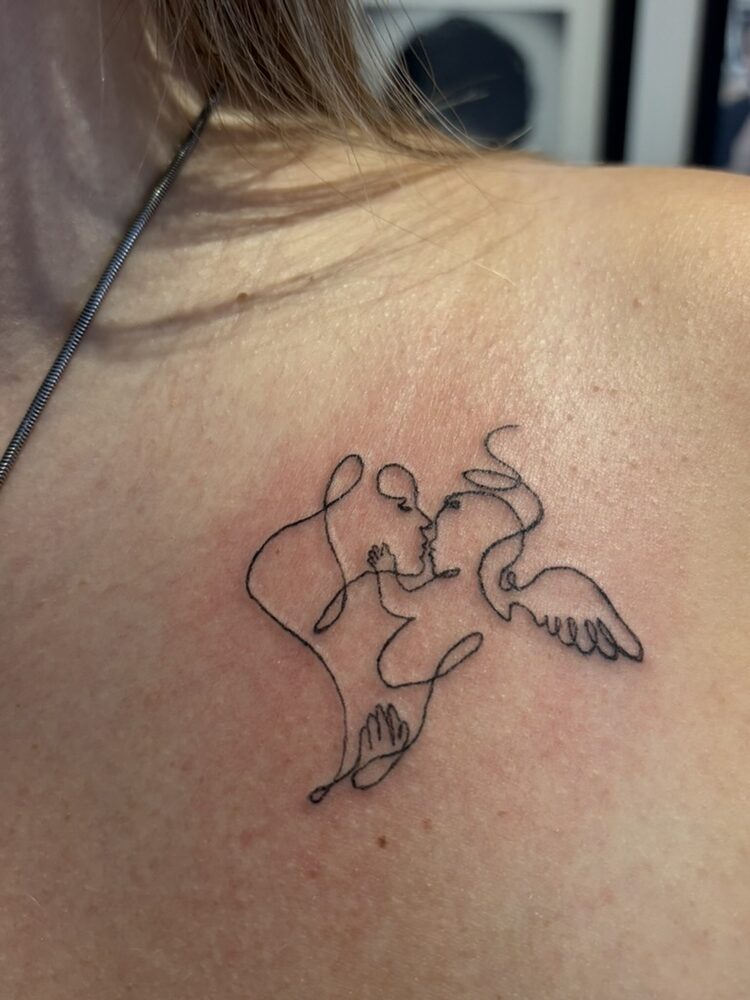 Continuous line art faces tattoo on the shoulder